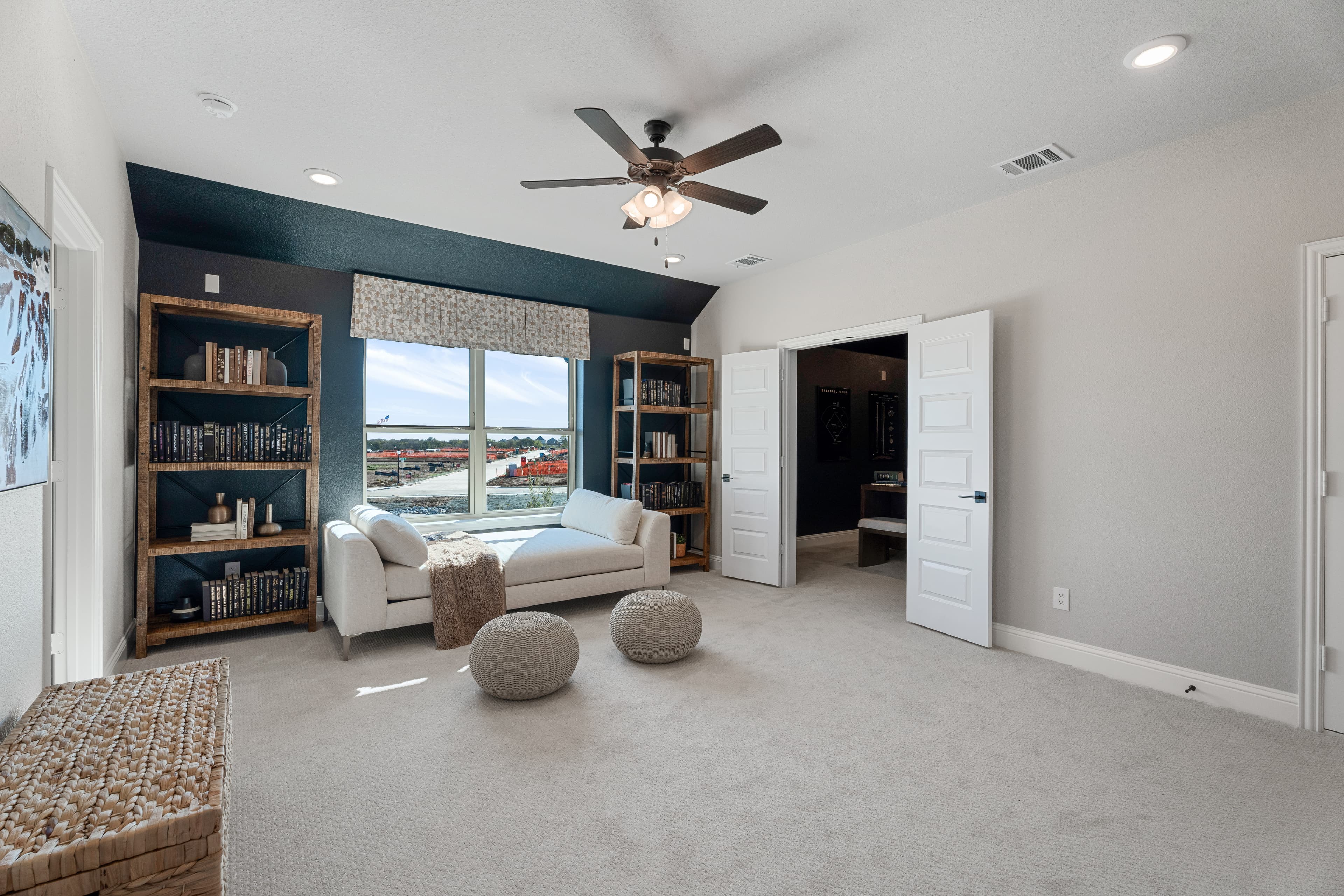 open loft with carpet, window, and ceiling fan
