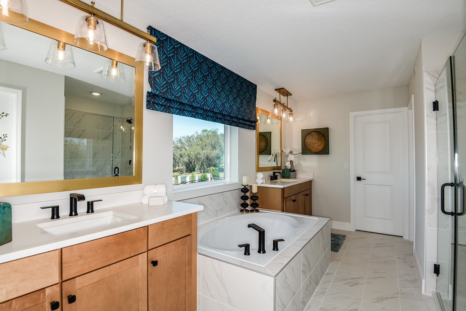 primary bathroom with tub and maple cabinets