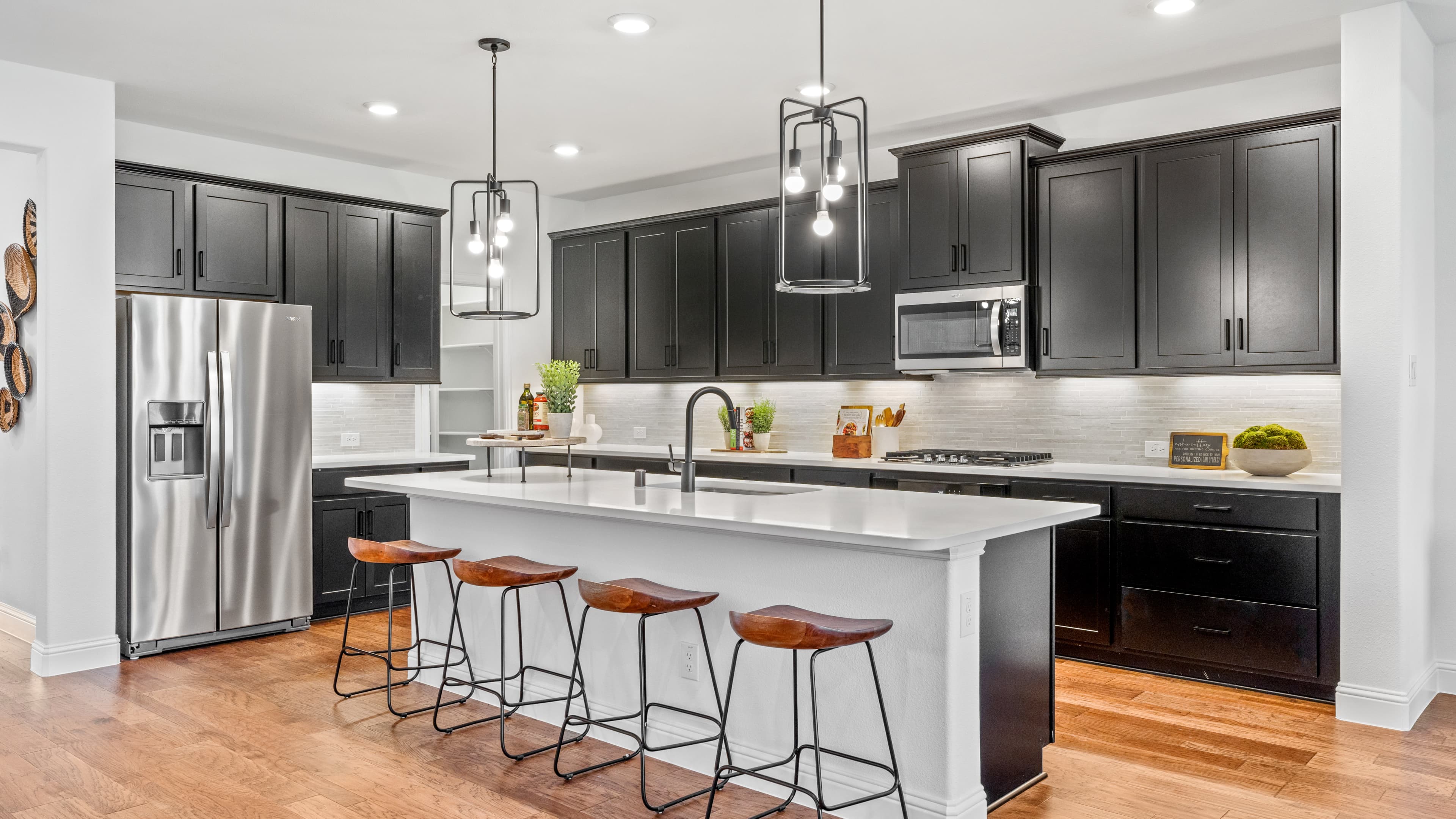 open kitchen with dark cabinets and wood floors