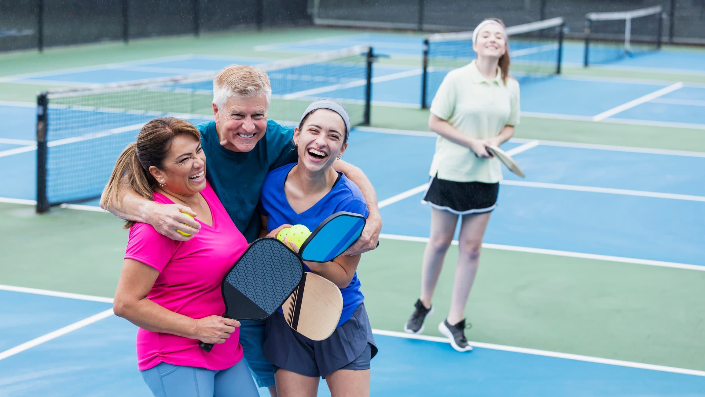 pickleball courts with a family hugging on them