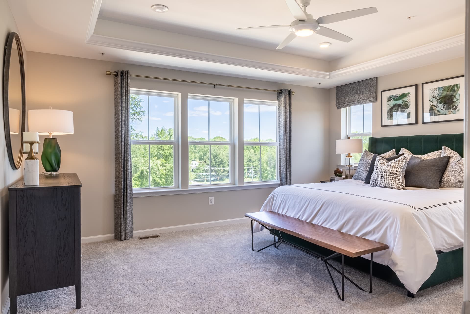 primary suite with a box ceiling and fan