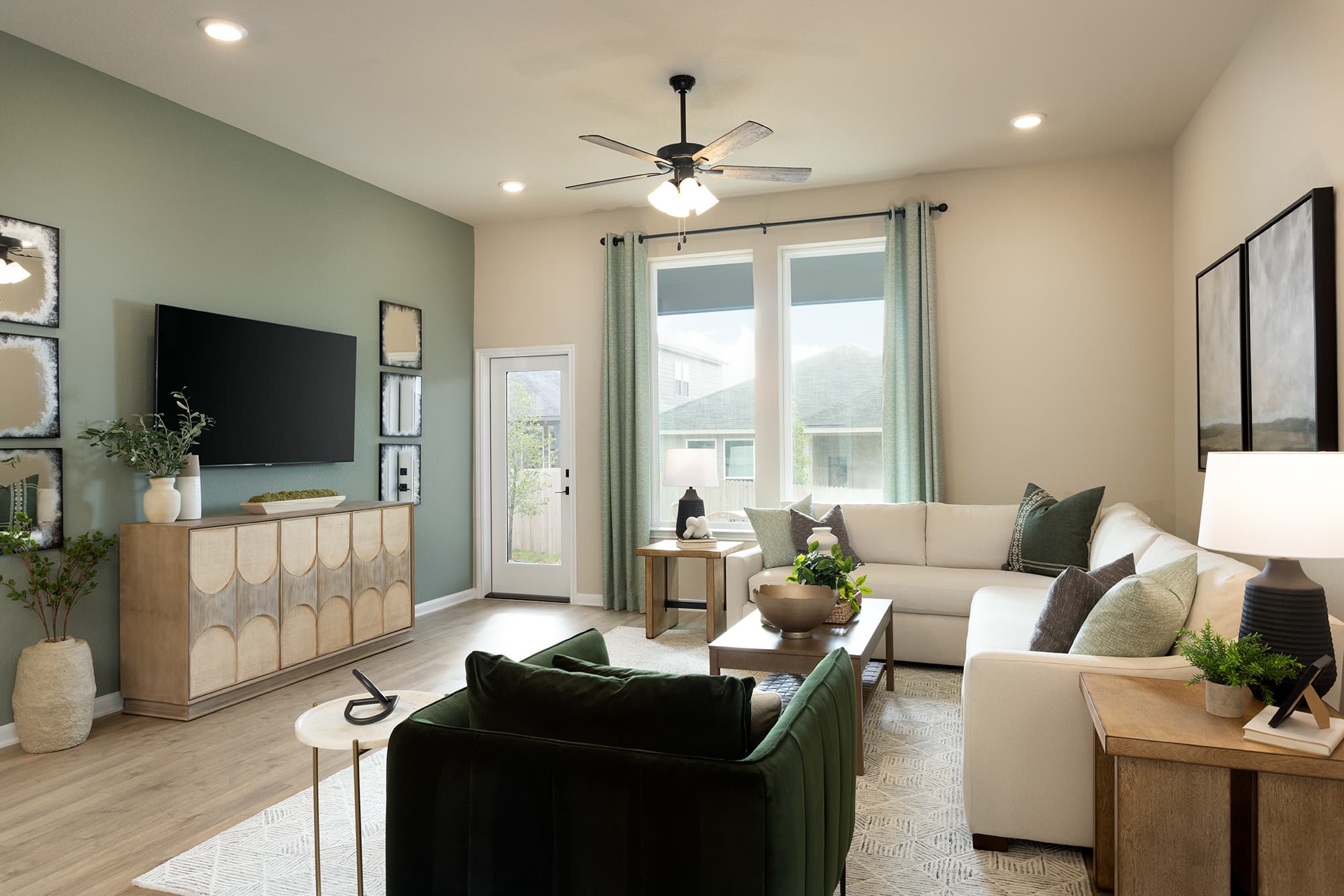 great room with a couch, windows & ceiling fan