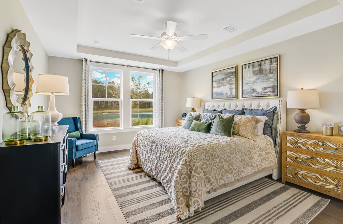 primary bedroom with hardwoods and bright windows