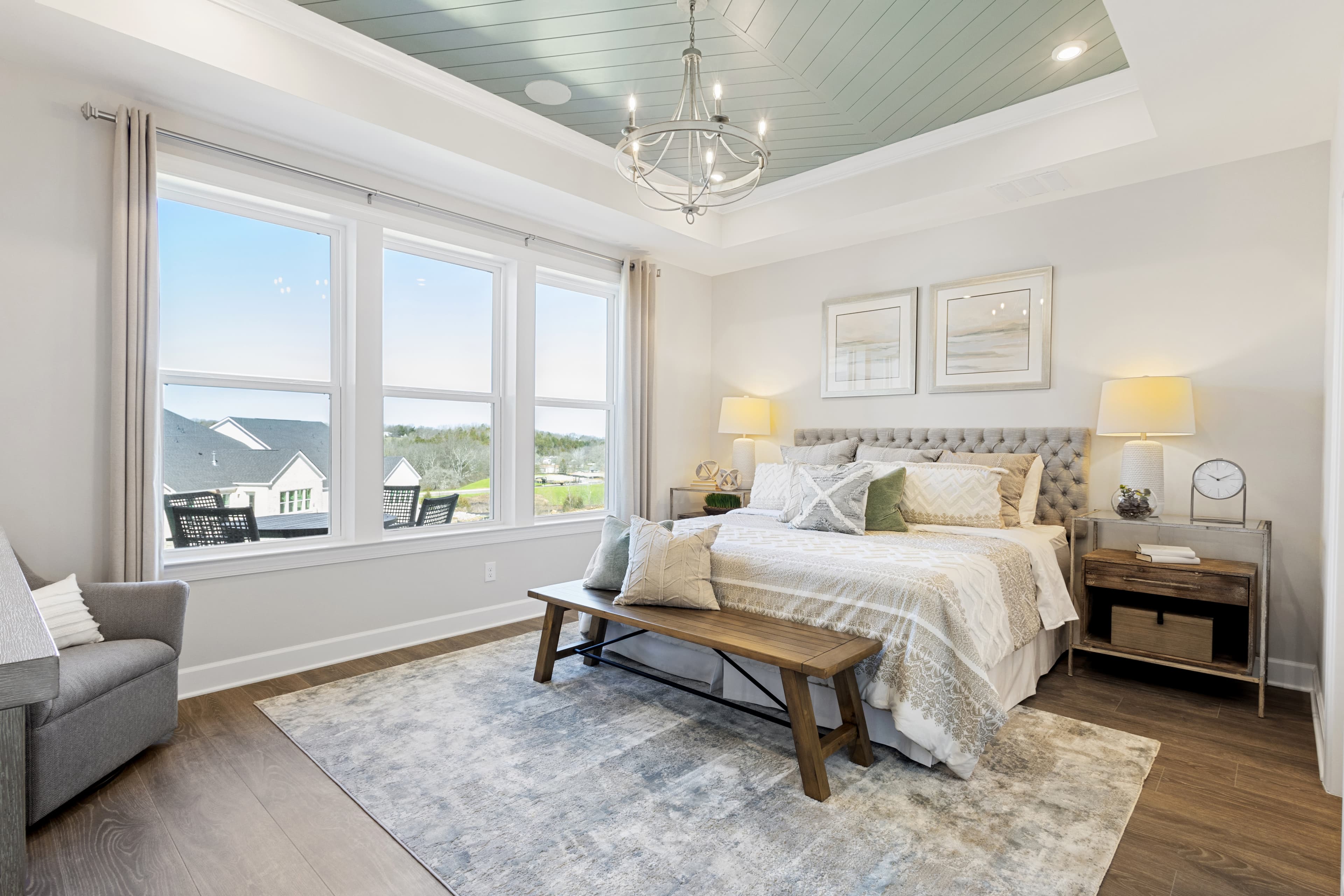 bedroom with tray ceiling and large windows
