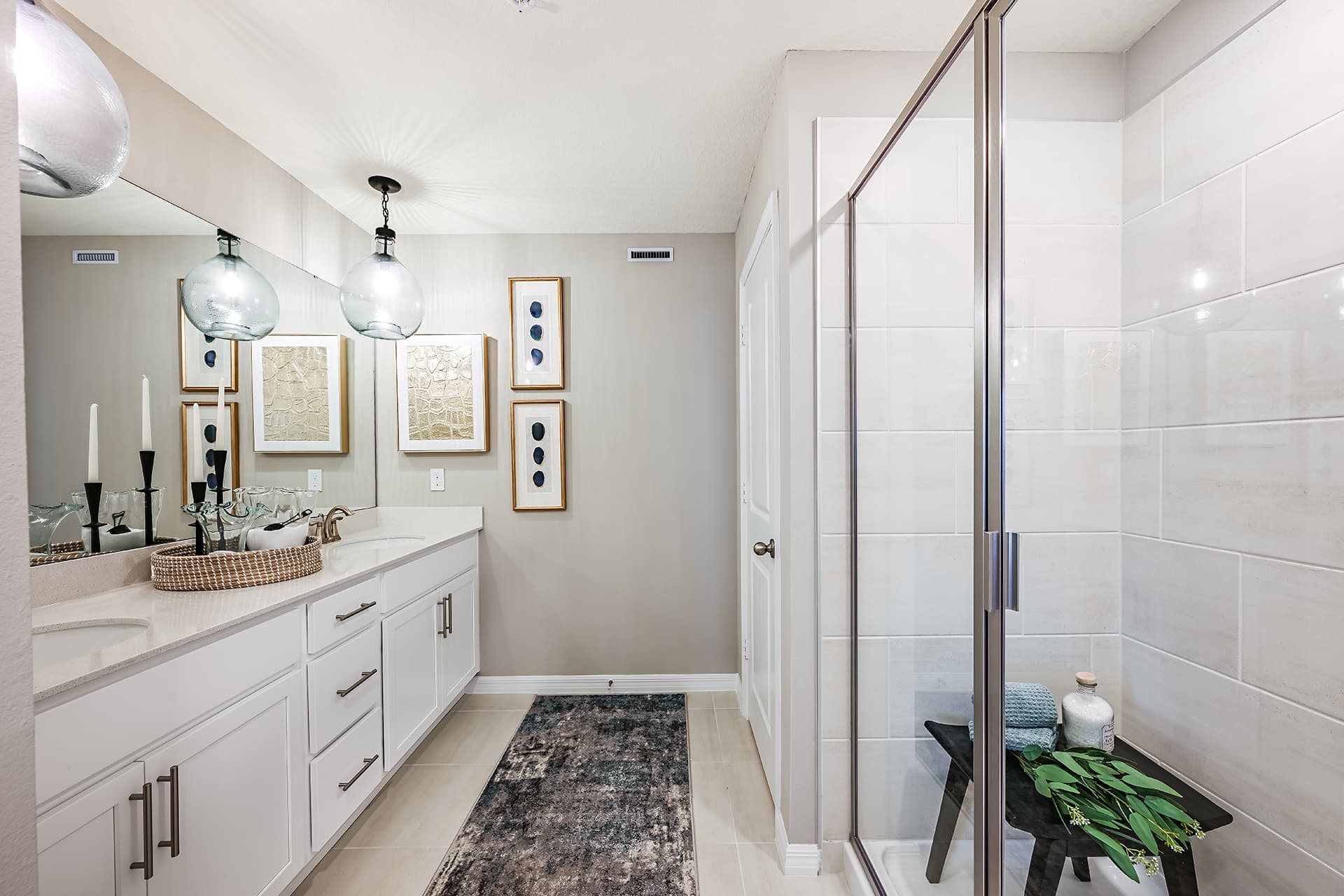 primary bathroom with tile shower and dual sinks