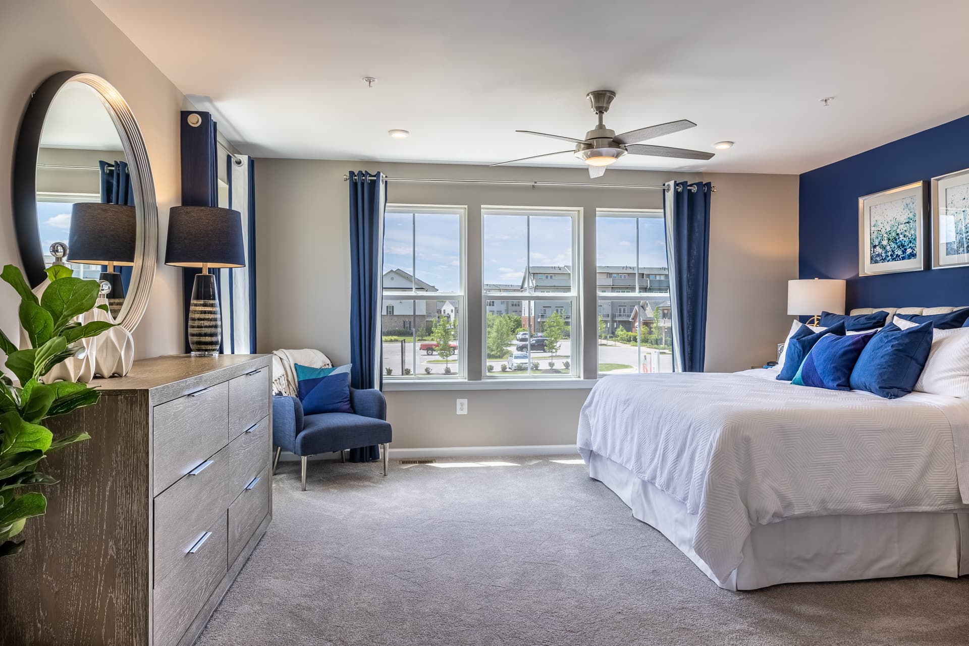 primary suite with carpet and a ceiling fan