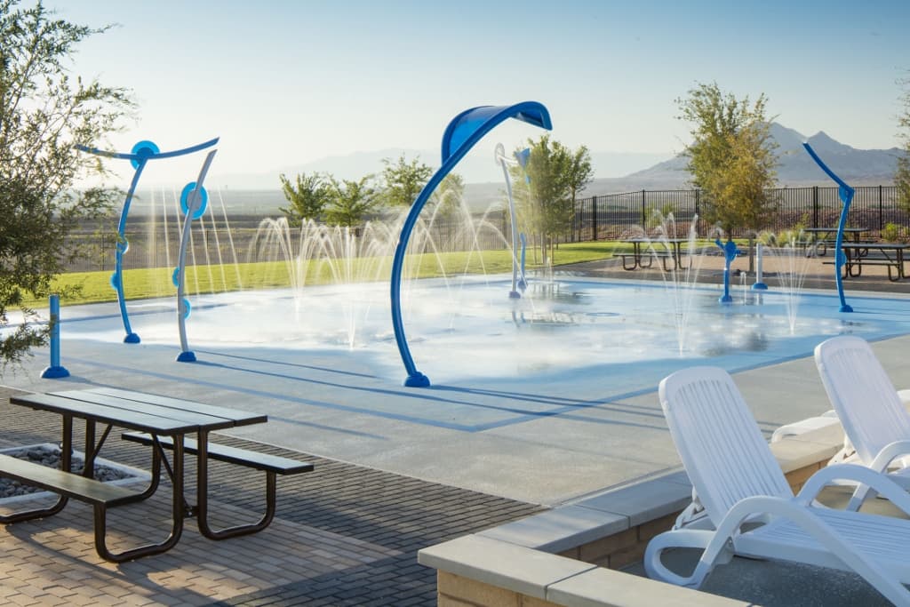 blue splash pad with water and lounge chairs