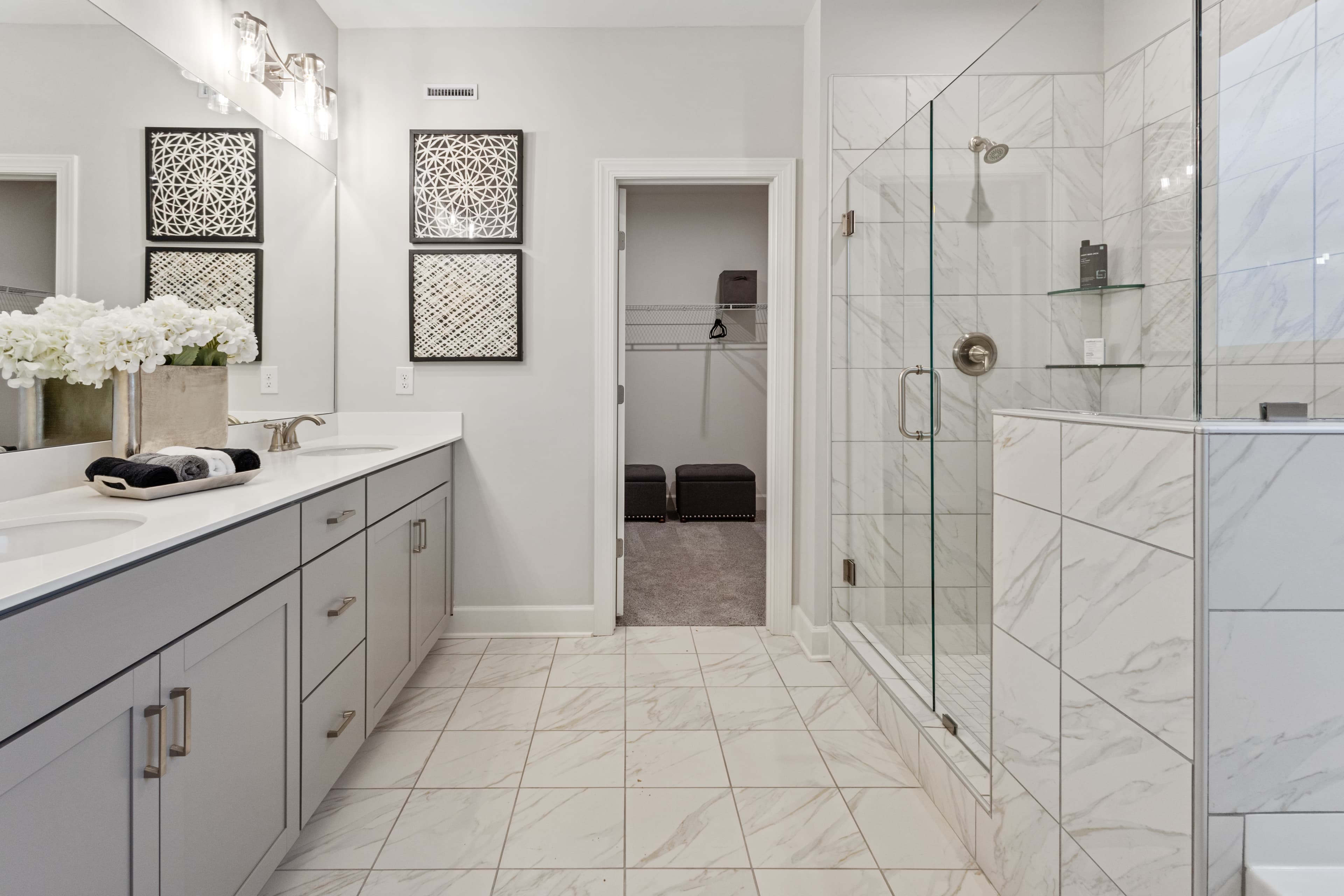 bathroom with grey cabinets and marble tile